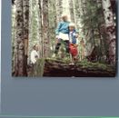 FOUND COLOR  PHOTO K_9362 TWO KIDS STANDING ON A MOSSY LOG IN THE FOREST